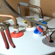Water Heater leaking from the top. image of top of water heater with tools.