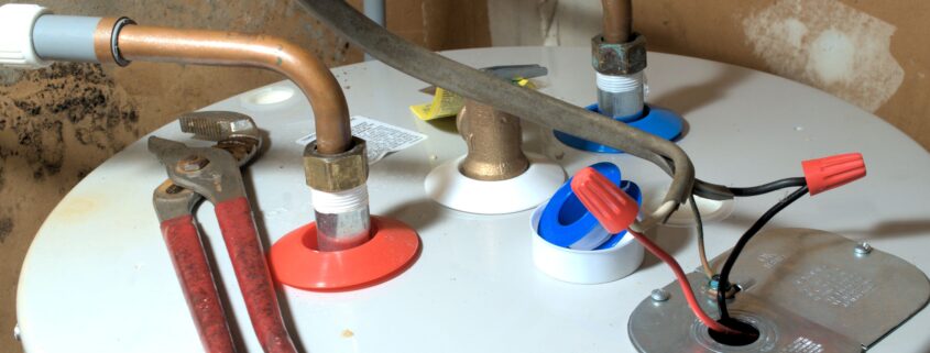 Water Heater leaking from the top. image of top of water heater with tools.